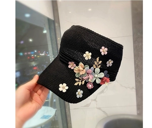 Detailed close-up of handmade floral decorations and faux pearls on black sun visor