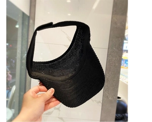 Detail of black knitted sun visor showing breathable weave and adjustable velcro strap