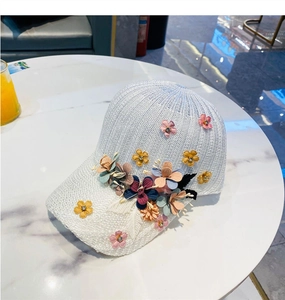 Detail of white mesh baseball cap featuring 3D floral embroidery and decorative rhinestones