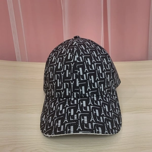 Close-up of black baseball cap with white Eiffel Tower and alphabet patterns