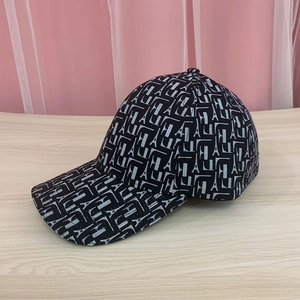 Detail view of baseball cap with Eiffel Tower and alphabet patterns on black fabric