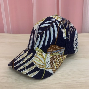 Detail of tropical leaf print on navy baseball cap with classic curved brim design
