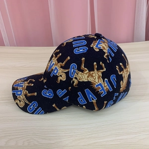 Detail of baseball cap featuring horse and letter embroidery on navy fabric surface