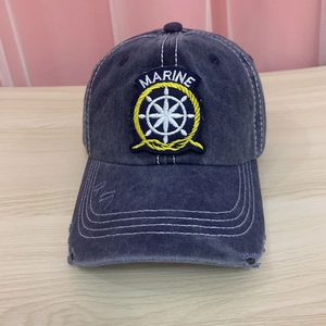 Detailed view of the embroidered marine patch and worn-out effects on a washed cotton cap