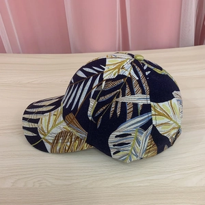 Detail of tropical palm leaf print on a dark cotton baseball cap with curved brim