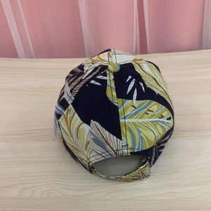 Detail of adjustable metal buckle and tropical leaf print on navy baseball cap