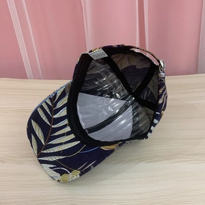 Navy blue baseball cap with gold tropical leaf prints showing inner lining and sweatband