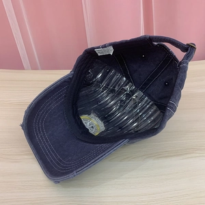 Inside view of distressed navy cotton baseball cap with adjustable metal strap