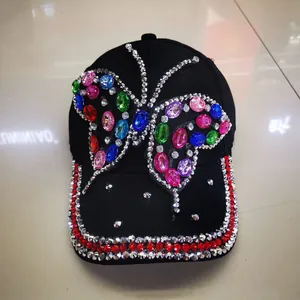 Detail of baseball cap featuring a large butterfly pattern made of colorful rhinestones