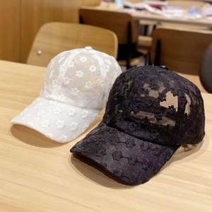 Dettaglio di ricamo in pizzo traforato con stelle e fiori sui cappellini da baseball