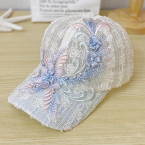 Close-up of white lace baseball cap featuring 3D floral embroidery and pearl accents