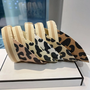 Detail of four leopard print knit headbands in pink, yellow, white, and golden brown colors