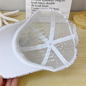 Detailed interior of white lace baseball cap with breathable mesh and shiny sequins