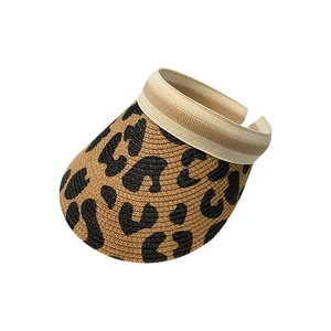 Detail of leopard print straw sun visor with breathable weave and elastic striped band