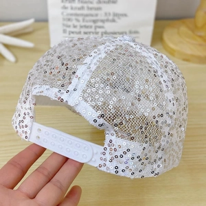 Close-up of sparkling silver sequins and adjustable strap on a breathable lace baseball cap