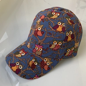Close-up of owl pattern print on navy cotton baseball cap showing stitching details