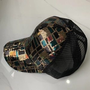 Détail de paillettes sur casquette avec motif à carreaux colorés et filet respirant