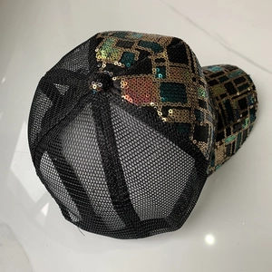 Détail du tissu en maille noire respirante et des paillettes colorées sur la casquette