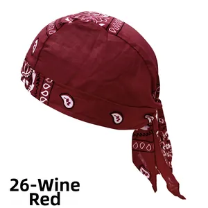 Detail view of wine red pirate bandana with white paisley patterns and cotton texture