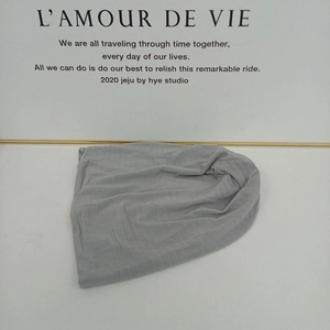 Detail view of lightweight light grey knitted beanie showing soft cotton blend texture