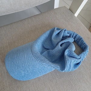 Detail of light blue sun visor hat featuring breathable crinkled texture fabric