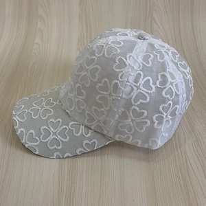 Close-up of white breathable lace mesh baseball cap with heart embroidery detail