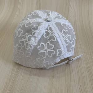 Close-up of white mesh baseball cap with heart embroidery and adjustable back strap