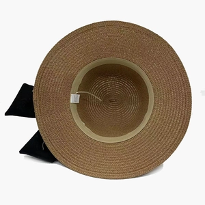 Women's brown straw sun hat with large black ribbon bow and internal sweatband detail