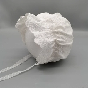 Detail of baby girl white lace sun hat with floral embroidery and delicate scalloped edges