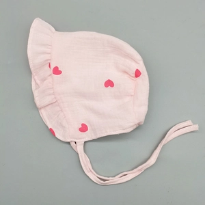 Detail von rosa Babyhaube mit rotem Herzmuster und atmungsaktivem Baumwollbesatz