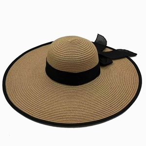Close-up of wide black ribbon bow and textured straw weave on a sun beach hat