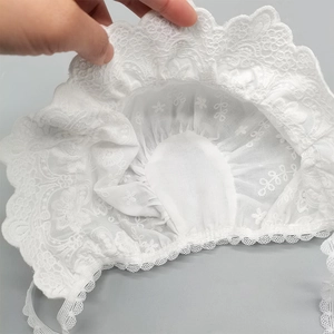 Close-up of white baby lace sun hat showing intricate embroidery and wavy mesh edge