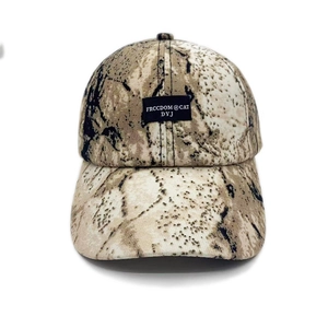 Detail view of camouflage baseball cap featuring a black rectangular lettered patch on front