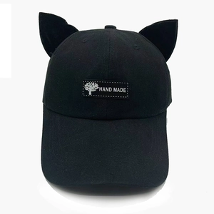 Détail d'une casquette en coton noir avec oreilles de chat et étiquette Hand Made