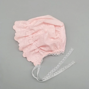 Detailed close-up of pink baby sun hat featuring embroidered fabric and scalloped lace trim