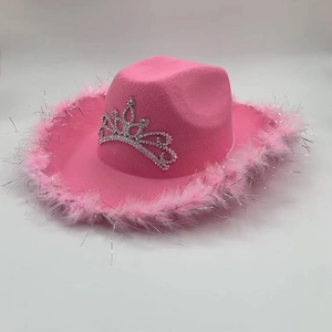 Détail d'un chapeau de cowboy rose avec emblème couronne argentée et bord en plumes
