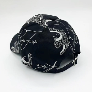 Detail of adjustable metal buckle and Eiffel Tower graffiti on black baseball cap