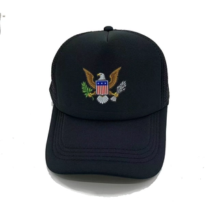 Close-up of black trucker hat featuring an American eagle crest and breathable mesh back