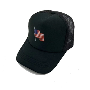 Detail einer schwarzen Trucker-Mütze mit Netzrücken und gestickter US-Flagge vorne