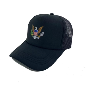 Top view of black mesh trucker hat featuring an eagle shield patch and curved brim