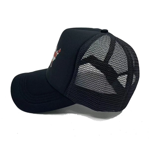 Detail view of black mesh trucker hat with festive red and white Santa Claus pattern