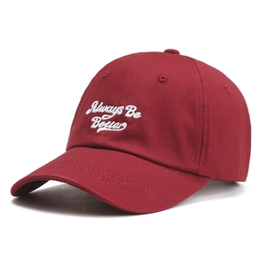 Classic burgundy cotton baseball cap with Always Be Better white embroidery on white background