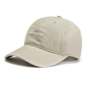 Detailed close-up of white 'Everyday' embroidery on washed cotton beige baseball cap