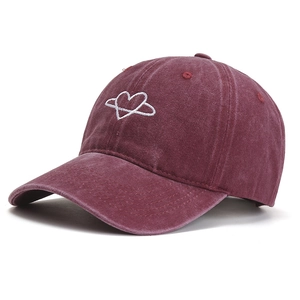 Burgundy washed cotton baseball cap with white heart embroidery on white background