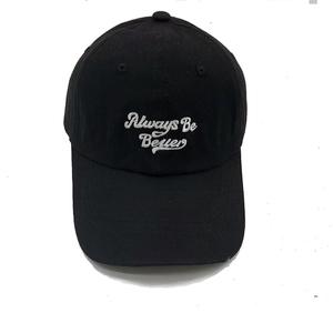 Detailed view of white Always Be Better embroidery on a black cotton canvas baseball cap