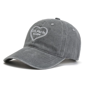 Close-up of heart-shaped Ofr Paris embroidery on a washed grey vintage baseball cap