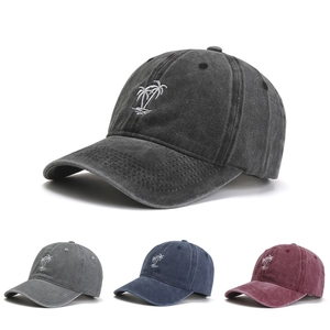 Detail view of retro washed cotton baseball caps with palm tree embroidery in multiple colors