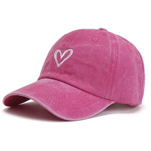 Washed pink cotton baseball cap featuring white heart embroidery and a vintage finish