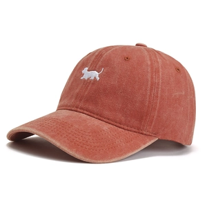 Vintage washed rust red cotton baseball cap featuring a white dog embroidery logo