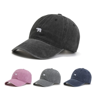 Close-up of polar bear embroidery on vintage washed cotton baseball caps in multiple colors